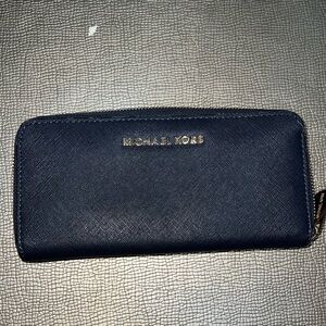 Michael Kors navy blue zip around leather wallet with gold tone hardware.